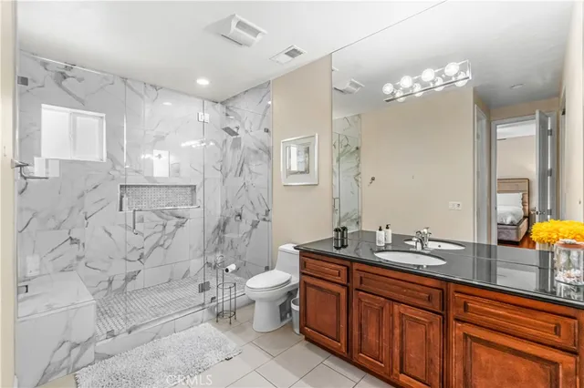 a spacious bathroom with a double vanity sink toilet mirror and shower