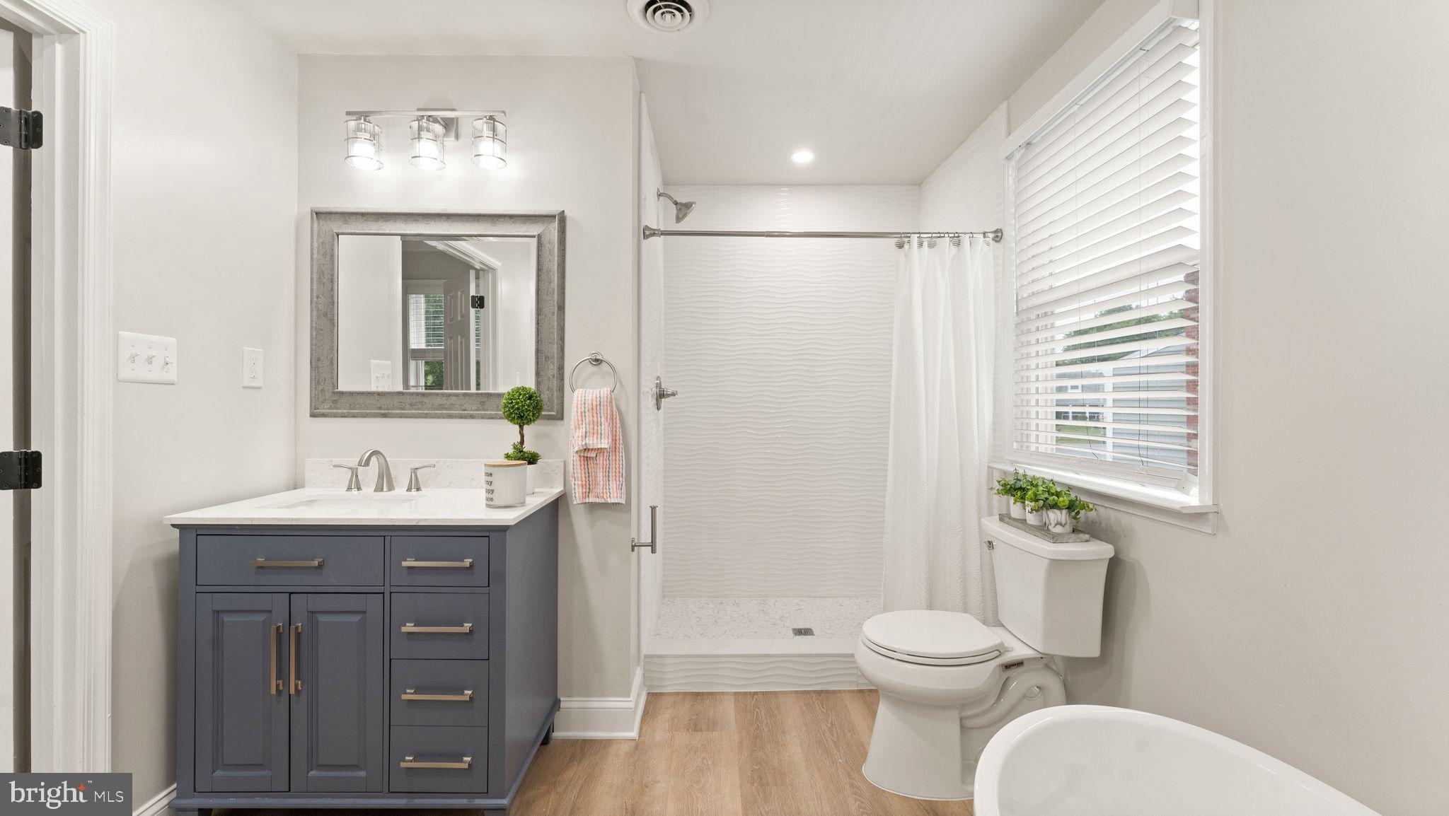 8309 Rolling Road Manassas, VA 20110 - Photo 48 of 70 a bathroom with a toilet a sink and mirror