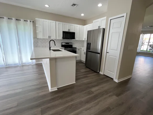 a kitchen with a refrigerator a stove top oven a sink and dishwasher