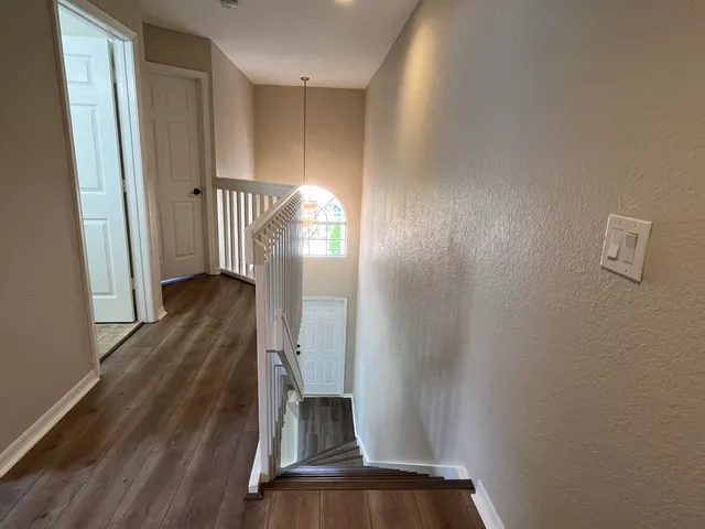 a view of a hallway with wooden floor