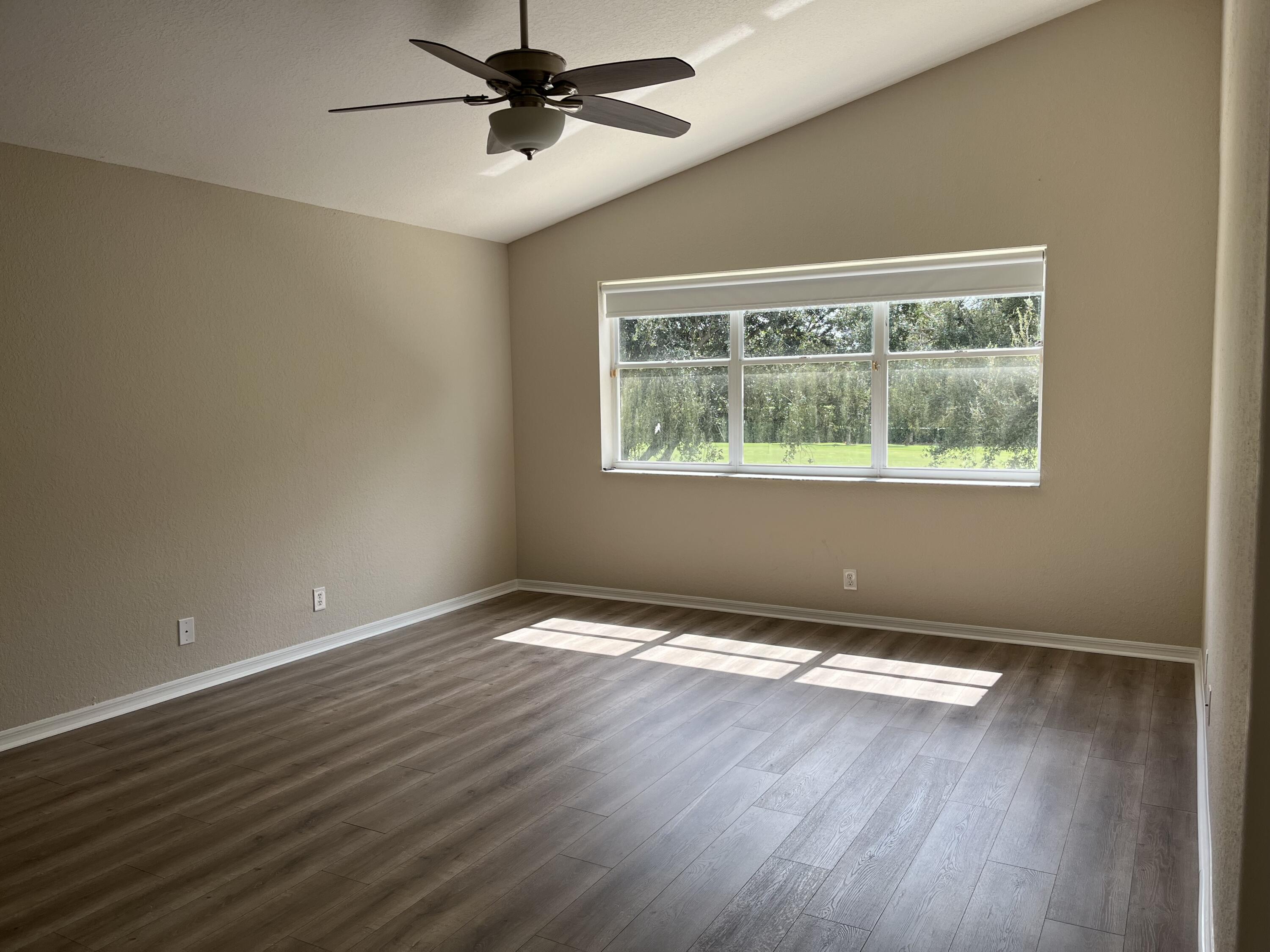 7299 Panache Way Boca Raton, FL 33433 - Photo 9 of 16 a view of an empty room with wooden floor and a window