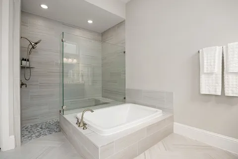 a white bath tub sitting next to a shower