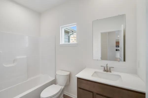 a bathroom with a sink toilet vanity and shower