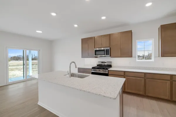 a kitchen with sink a microwave and cabinets