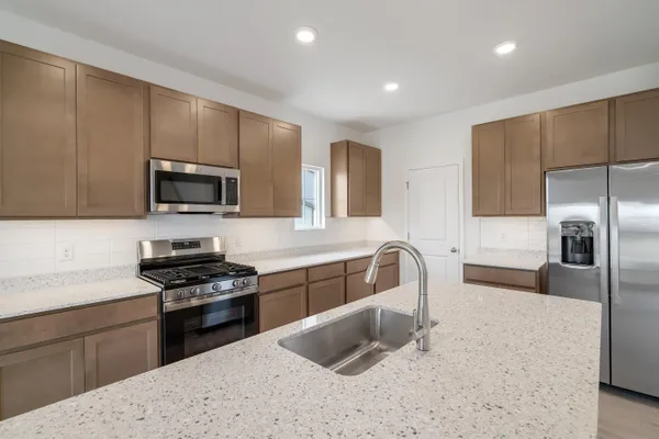 a kitchen with granite countertop a sink and stainless steel appliances