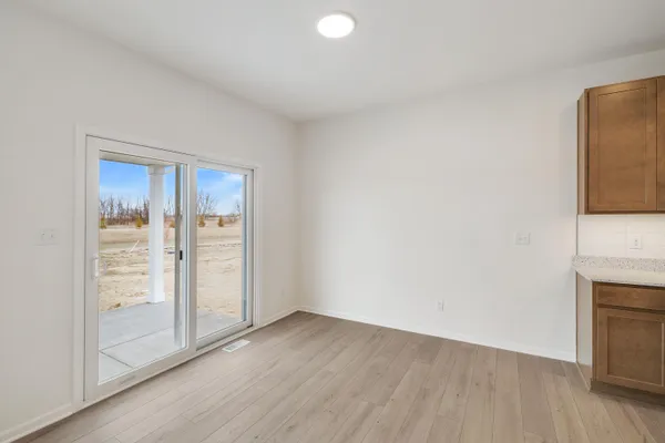 an empty room with wooden floor and sliding door