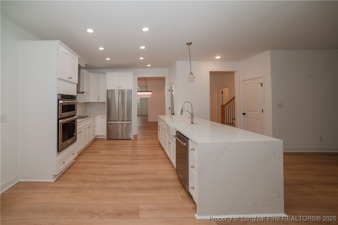 212 Stafford Avenue Raeford, NC 28376 - Photo 13 of 41 a view of a kitchen with refrigerator and wooden floor