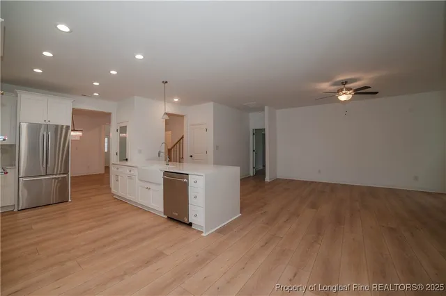 a kitchen with stainless steel appliances kitchen island wooden floors and view living room