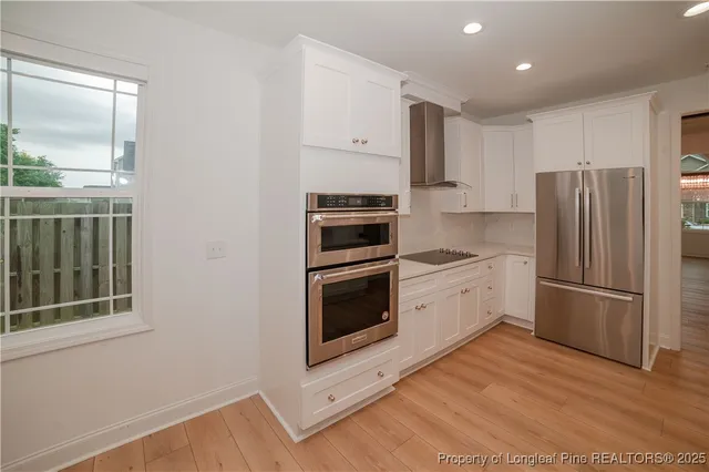 a kitchen with a refrigerator and a stove top oven