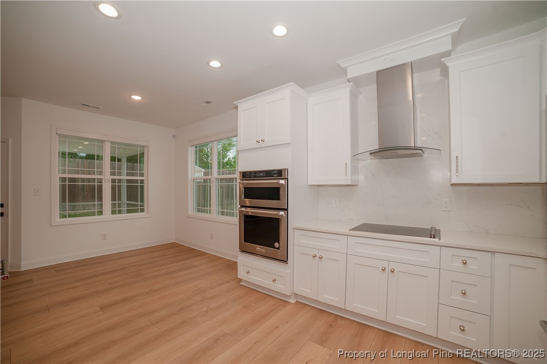 212 Stafford Avenue Raeford, NC 28376 - Photo 16 of 41 a kitchen with stainless steel appliances white cabinets and wooden floors