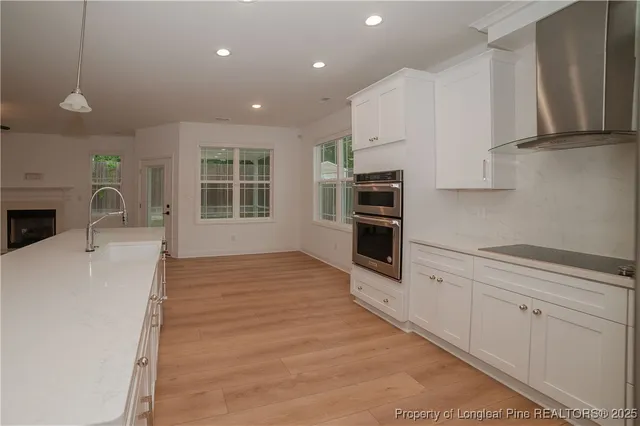 a kitchen with stainless steel appliances a stove top oven a sink a refrigerator and cabinets