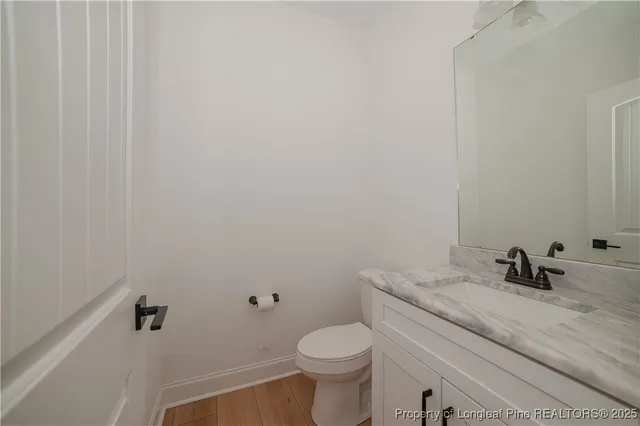 a bathroom with a granite countertop toilet and a sink