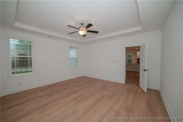 a view of empty room with wooden floor and ceiling fan