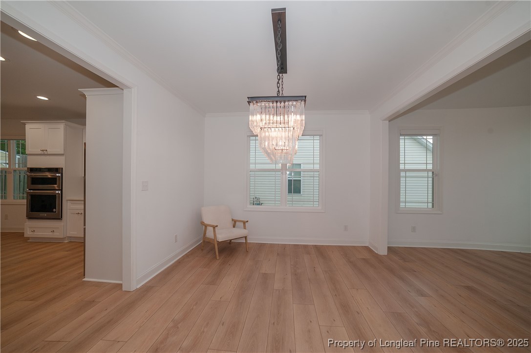 212 Stafford Avenue Raeford, NC 28376 - Photo 6 of 41 an empty room with wooden floor and windows