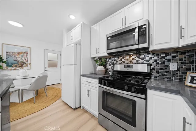 a kitchen with stainless steel appliances a stove a microwave and cabinets