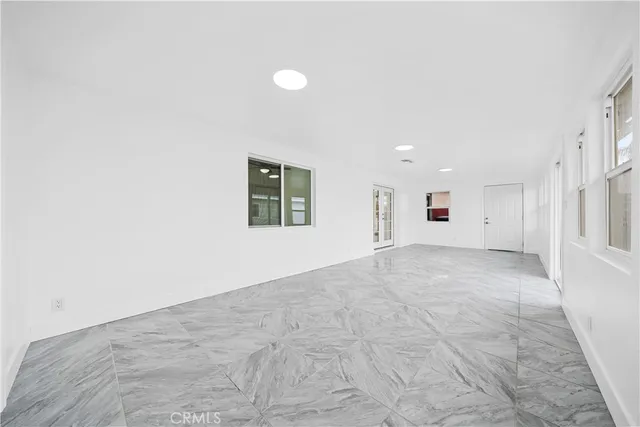 an empty room with a white walls and window