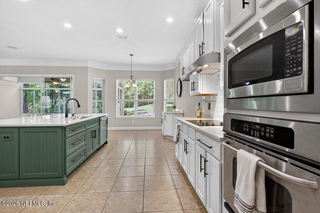 1664 Fairway Ridge Drive Fleming Island, FL 32003 - Photo 19 of 103 a large kitchen with stainless steel appliances kitchen island granite countertop a sink and cabinets
