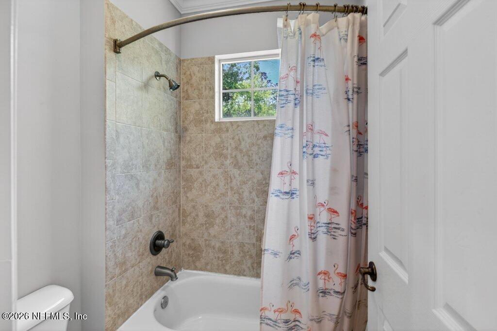 1664 Fairway Ridge Drive Fleming Island, FL 32003 - Photo 60 of 103 a bathroom with a shower curtain a window and a bath tub
