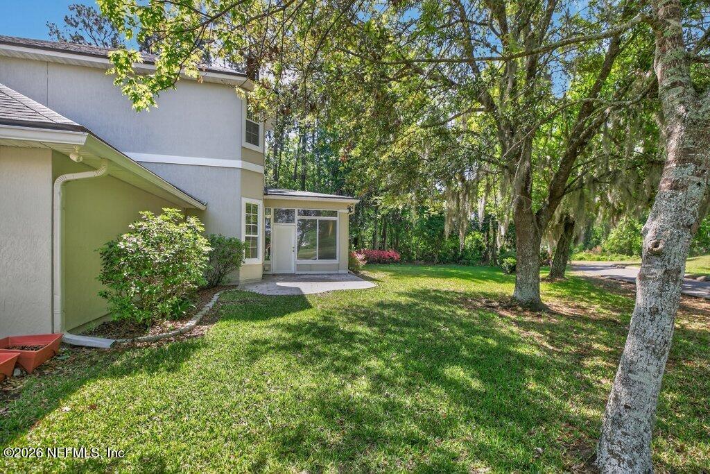 1664 Fairway Ridge Drive Fleming Island, FL 32003 - Photo 72 of 103 a backyard of a house with plants and large tree