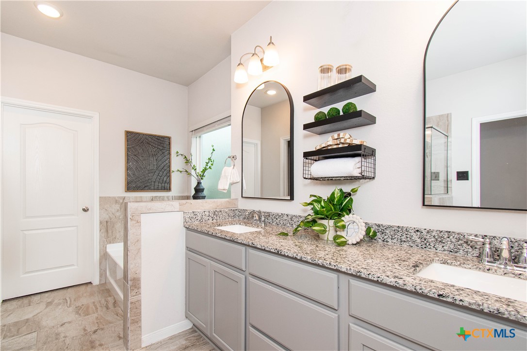 736 Jersey Court Troy, TX 76579 - Photo 11 of 32 a bathroom with a granite countertop sink and a mirror