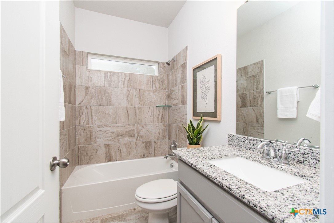 736 Jersey Court Troy, TX 76579 - Photo 16 of 32 a bathroom with a granite countertop toilet a sink and a bathtub