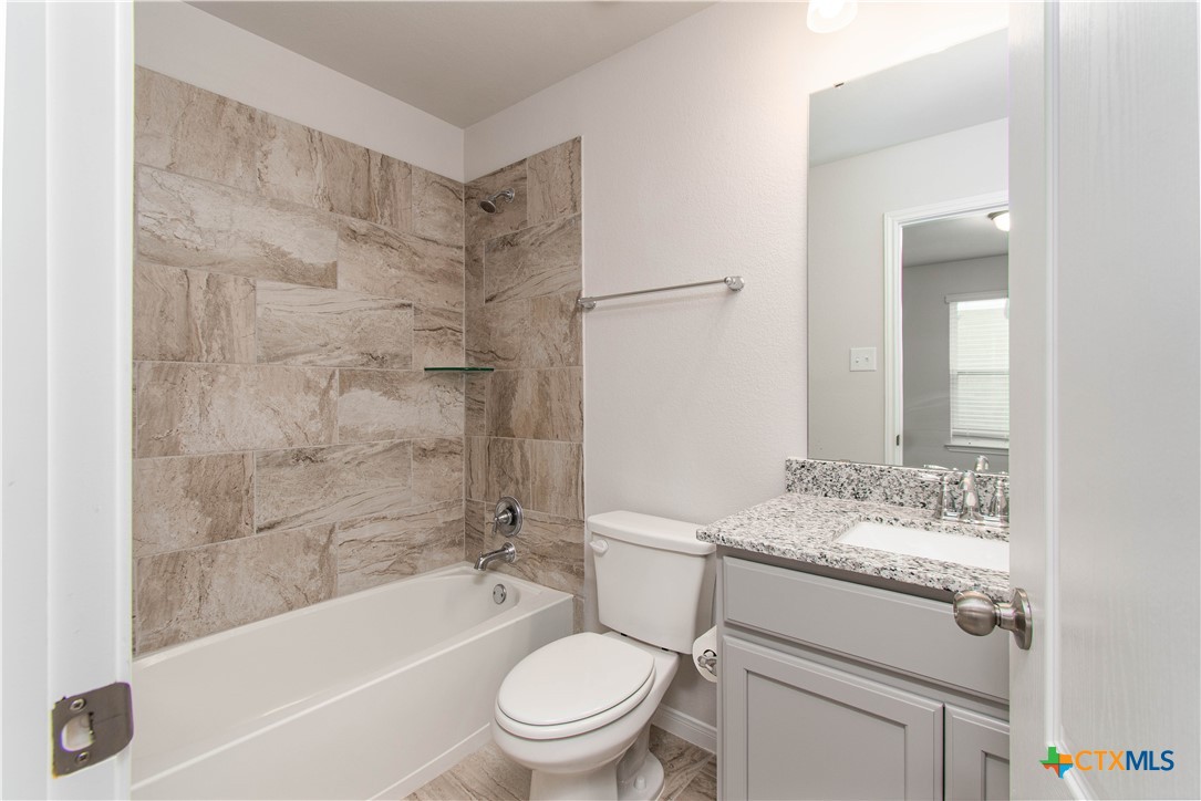 736 Jersey Court Troy, TX 76579 - Photo 23 of 32 a bathroom with a granite countertop toilet a sink and a bathtub
