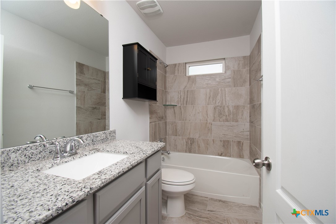 736 Jersey Court Troy, TX 76579 - Photo 27 of 32 a bathroom with a granite countertop sink a toilet and shower