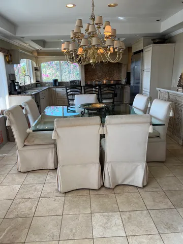 a living room with furniture a chandelier and kitchen view