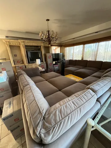 a living room with furniture and a chandelier
