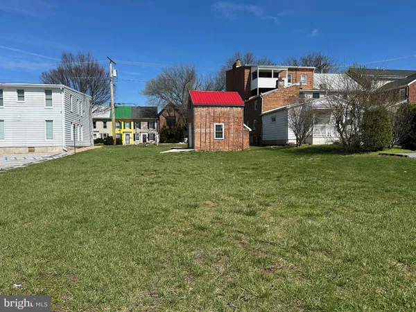 a view of a big house with a big yard and large trees