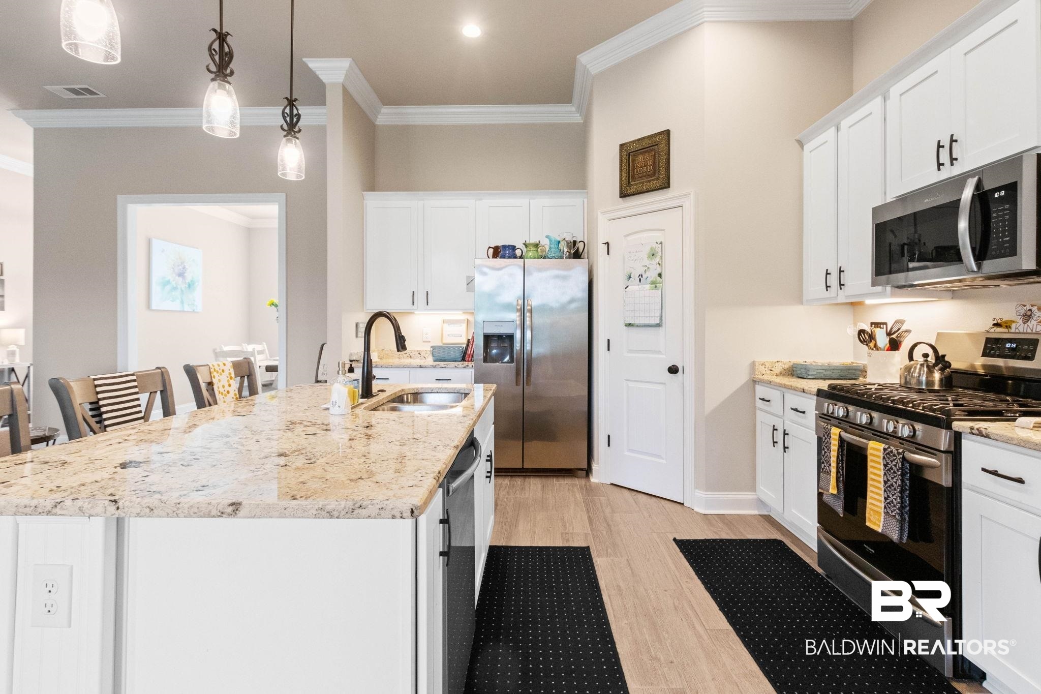 22244 Hibiscus Circle Foley, AL 36535 - Photo 24 of 51 Kitchen featuring a large island with stone countertops, white shaker cabinetry, stainless steel appliances, and wood-finish flooring