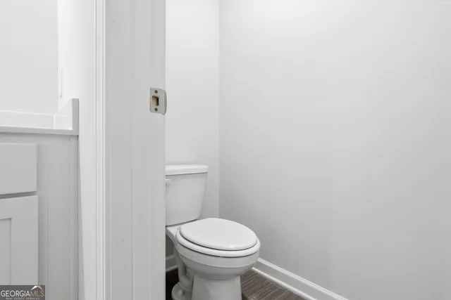 a white toilet sitting next to a white wall