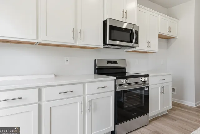 a kitchen with stainless steel appliances granite countertop white cabinets a sink and dishwasher