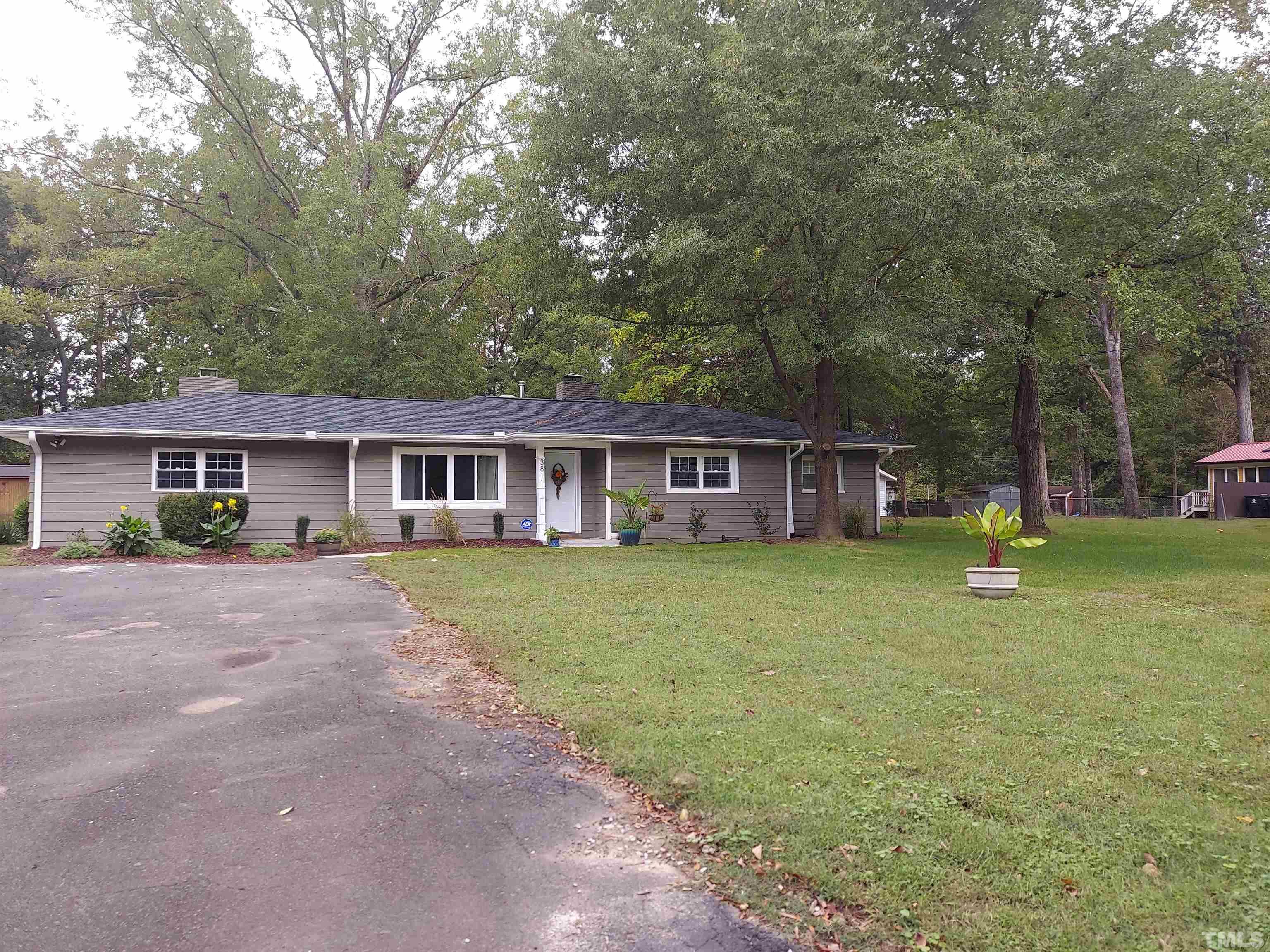 a view of a house with a yard and large tree