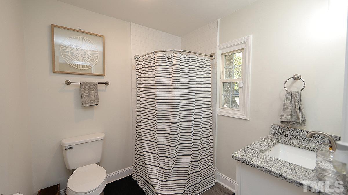 3811 Pickett Road Durham, NC 27705 - Photo 13 of 22 a bathroom with a sink a toilet and mirror
