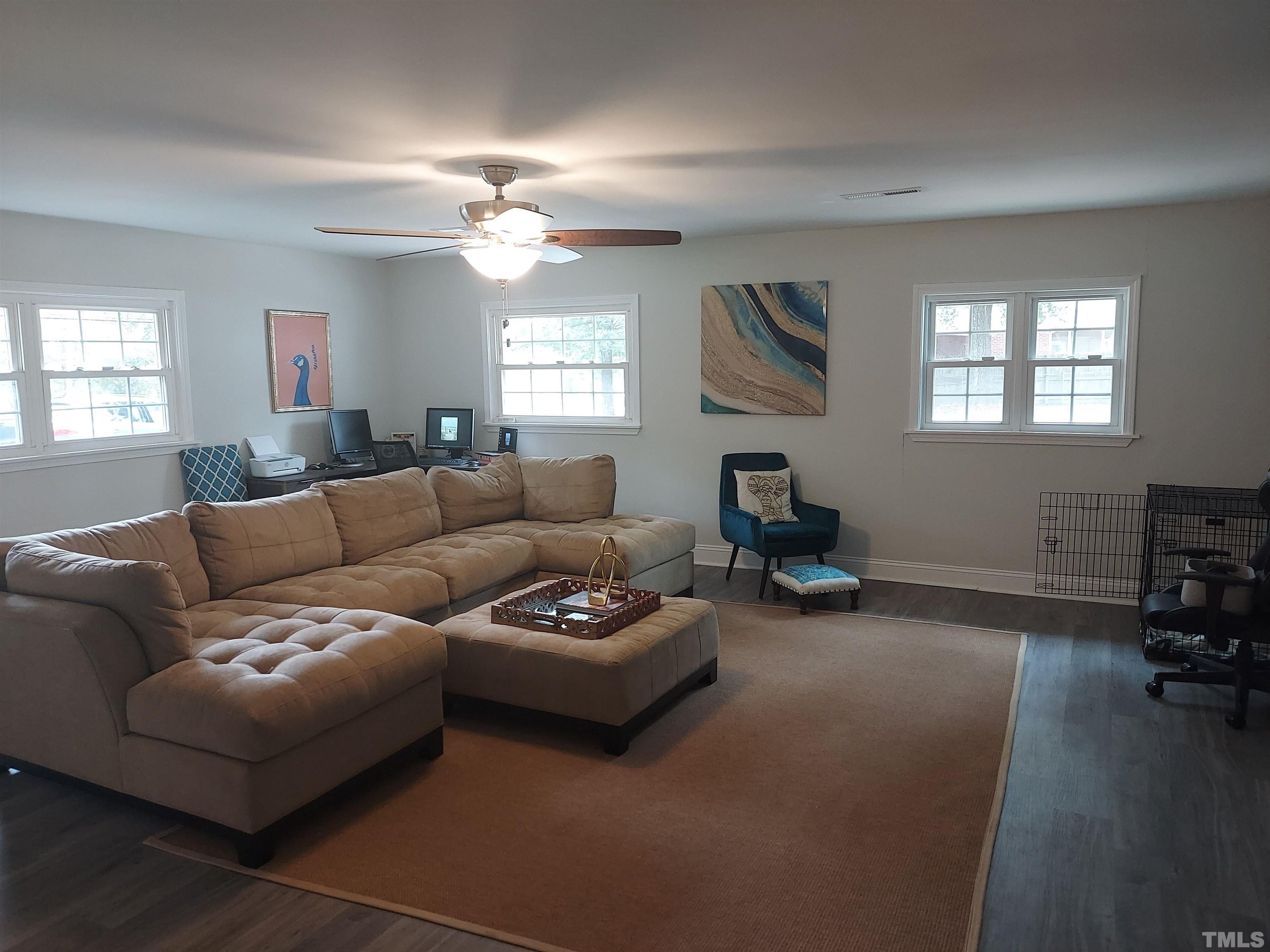 3811 Pickett Road Durham, NC 27705 - Photo 3 of 22 a living room with furniture a fireplace and a flat screen tv