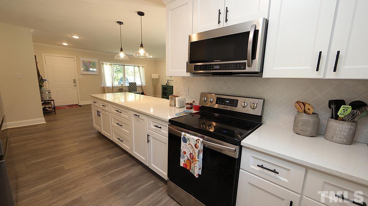 3811 Pickett Road Durham, NC 27705 - Photo 7 of 22 a kitchen with a sink stove and microwave