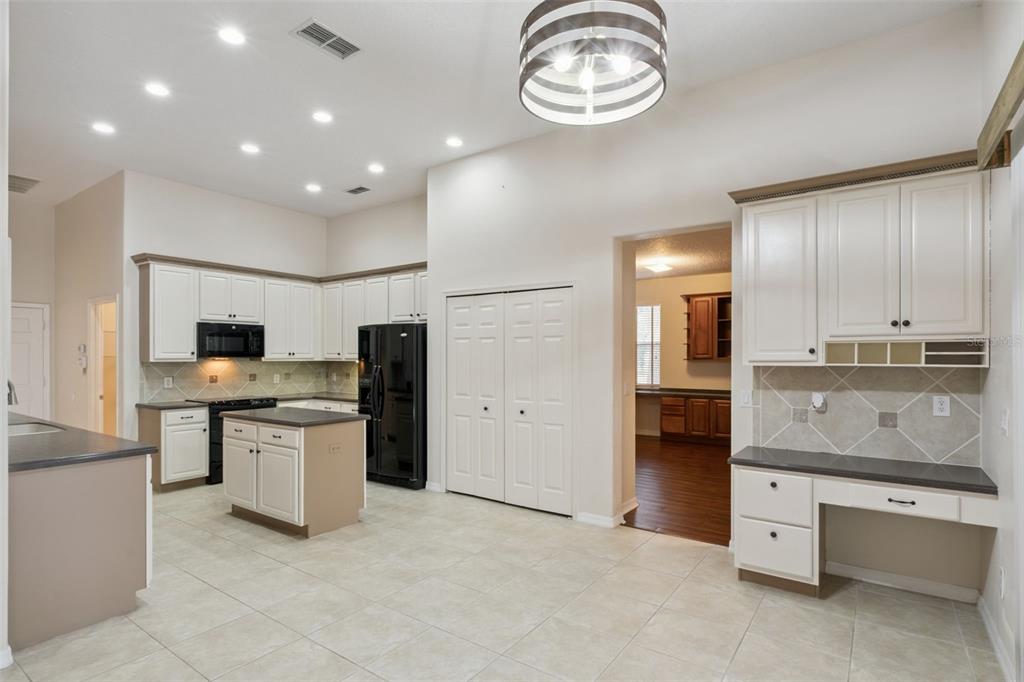 597 Sand Wedge Loop Apopka, FL 32712 - Photo 14 of 40 a kitchen with stainless steel appliances granite countertop a sink and cabinets