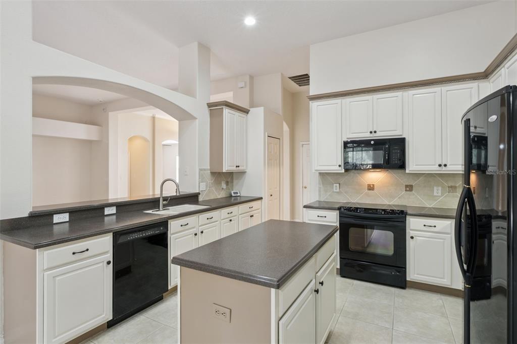 597 Sand Wedge Loop Apopka, FL 32712 - Photo 15 of 40 a kitchen with a sink stove and refrigerator