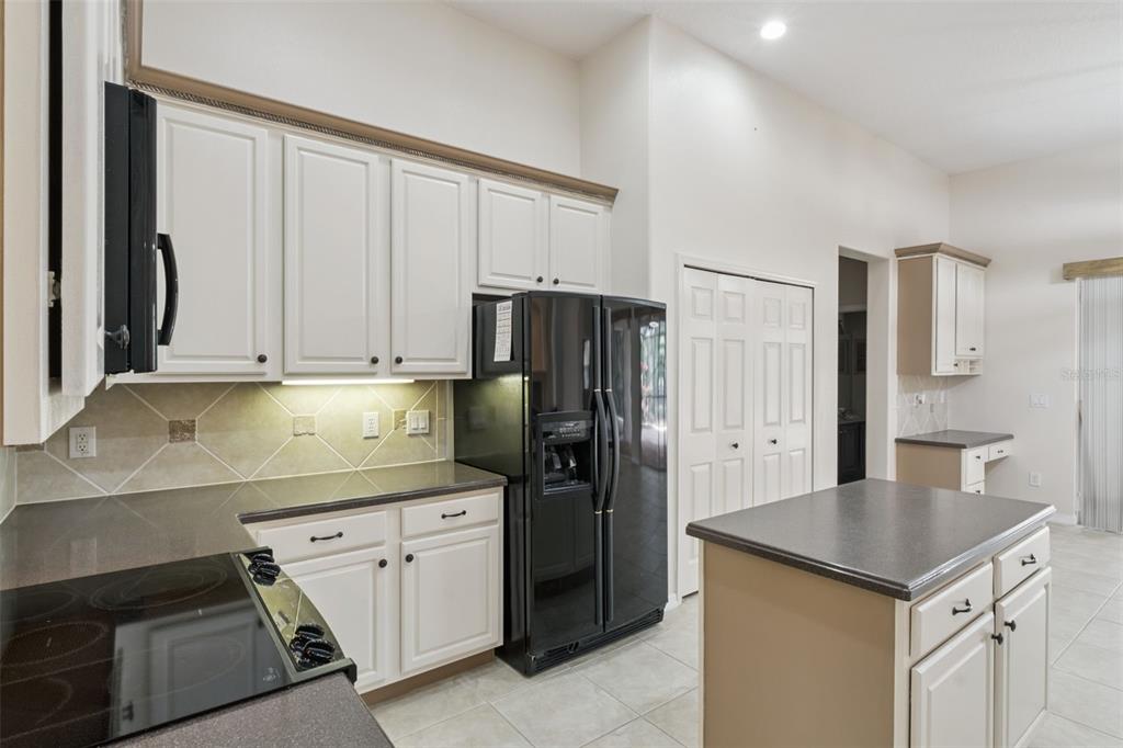 597 Sand Wedge Loop Apopka, FL 32712 - Photo 16 of 40 a kitchen with a refrigerator stove and cabinets