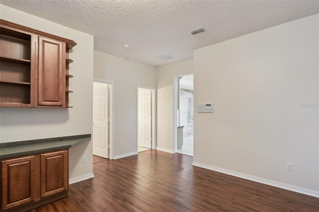 597 Sand Wedge Loop Apopka, FL 32712 - Photo 18 of 40 a view of an empty room with wooden floor and cabinet