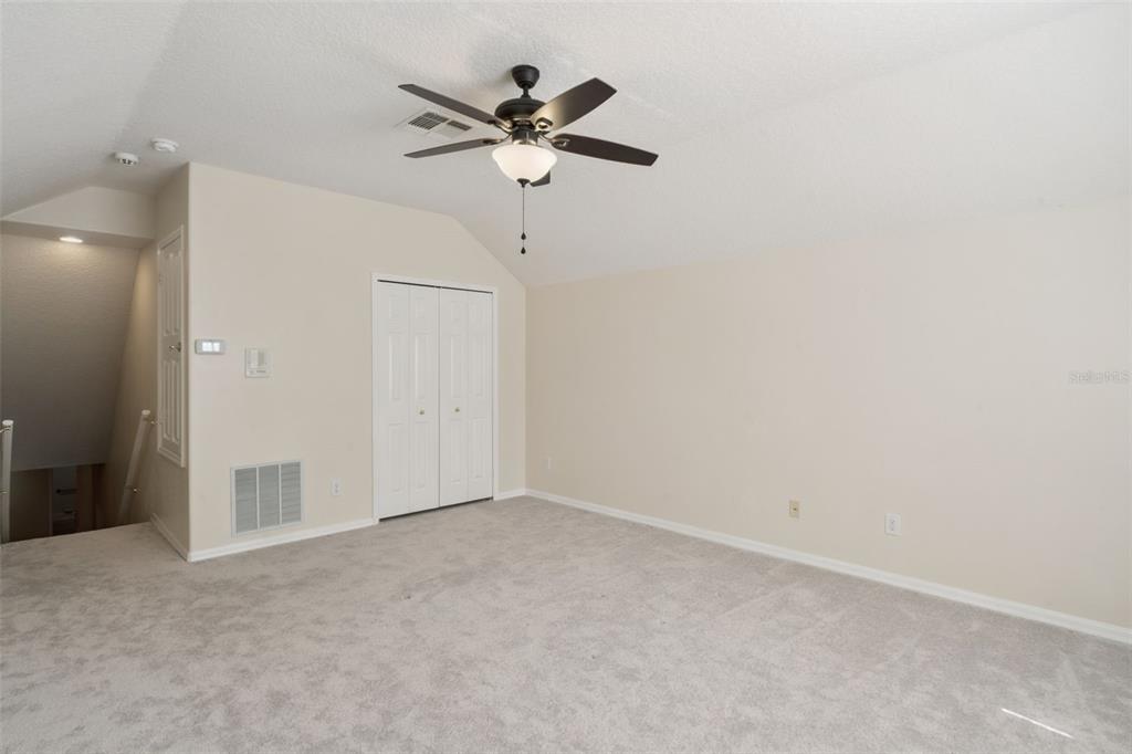 597 Sand Wedge Loop Apopka, FL 32712 - Photo 19 of 40 an empty room with a chandelier fan and a ceiling fan