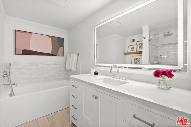 a bathroom with a tub sink and mirror