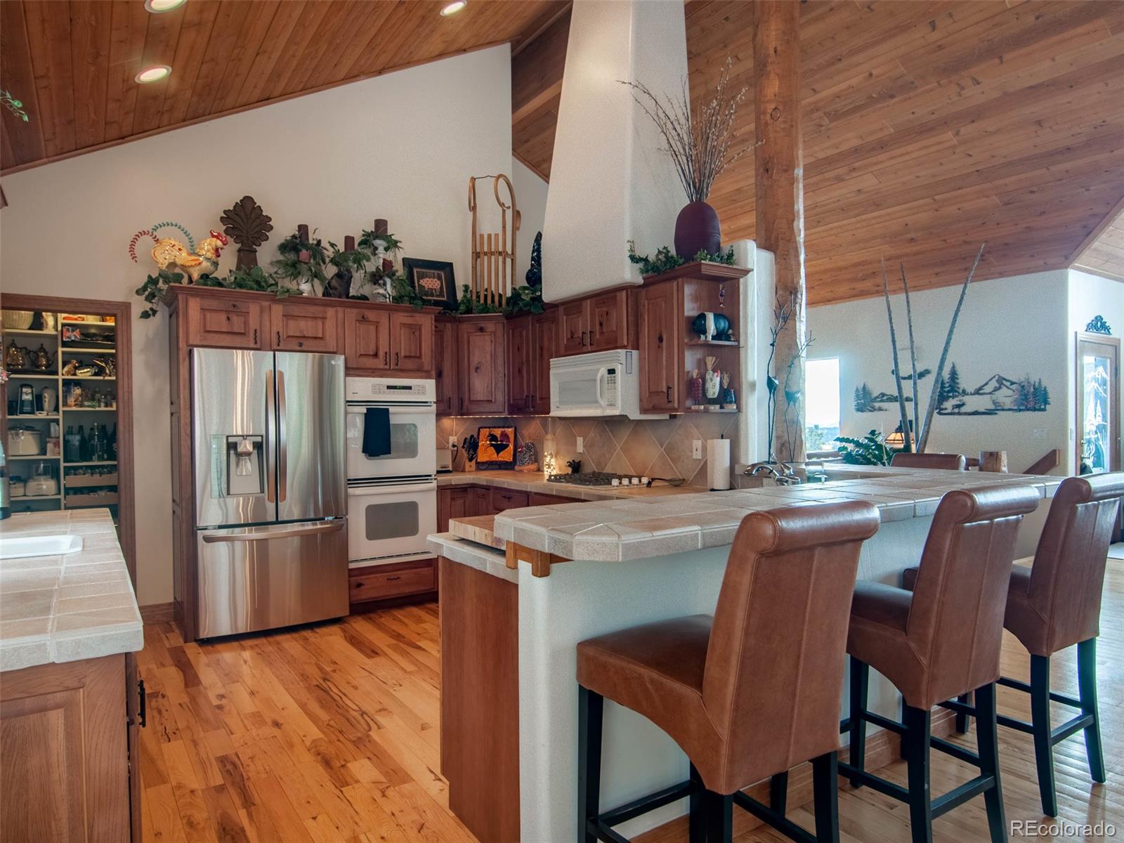 850 Royal Ridge Drive Bailey, CO 80421 - Photo 11 of 35 a kitchen with stainless steel appliances granite countertop a table chairs in it and wooden floors