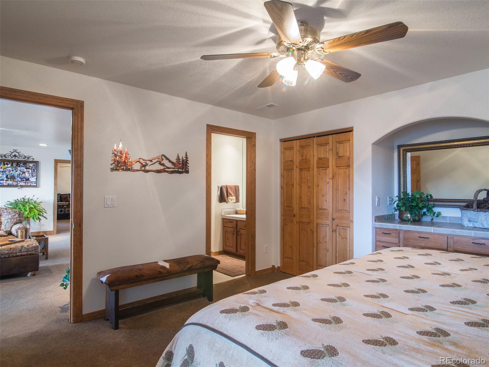 850 Royal Ridge Drive Bailey, CO 80421 - Photo 24 of 35 a bedroom with a bed a couch and a chandelier