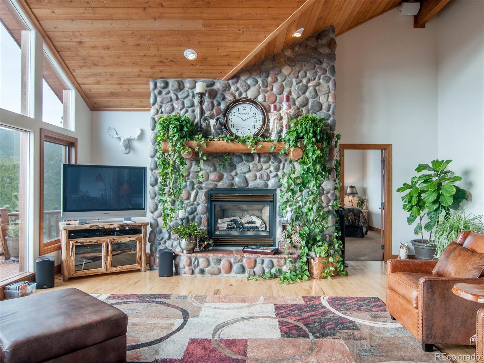 850 Royal Ridge Drive Bailey, CO 80421 - Photo 9 of 35 a living room with furniture a fireplace and a flat screen tv