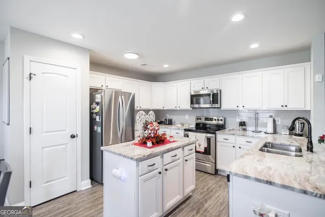 a kitchen with stainless steel appliances granite countertop a sink stove and microwave