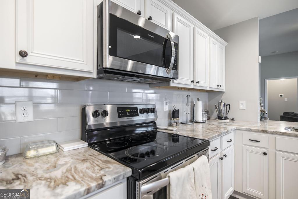 132 Sadie Heights Boulevard Perry, GA 31069 - Photo 14 of 29 a kitchen with stainless steel appliances granite countertop a sink stove and microwave
