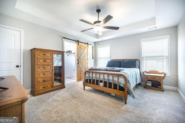 a bedroom with a bed and a flat tv screen on a dresser