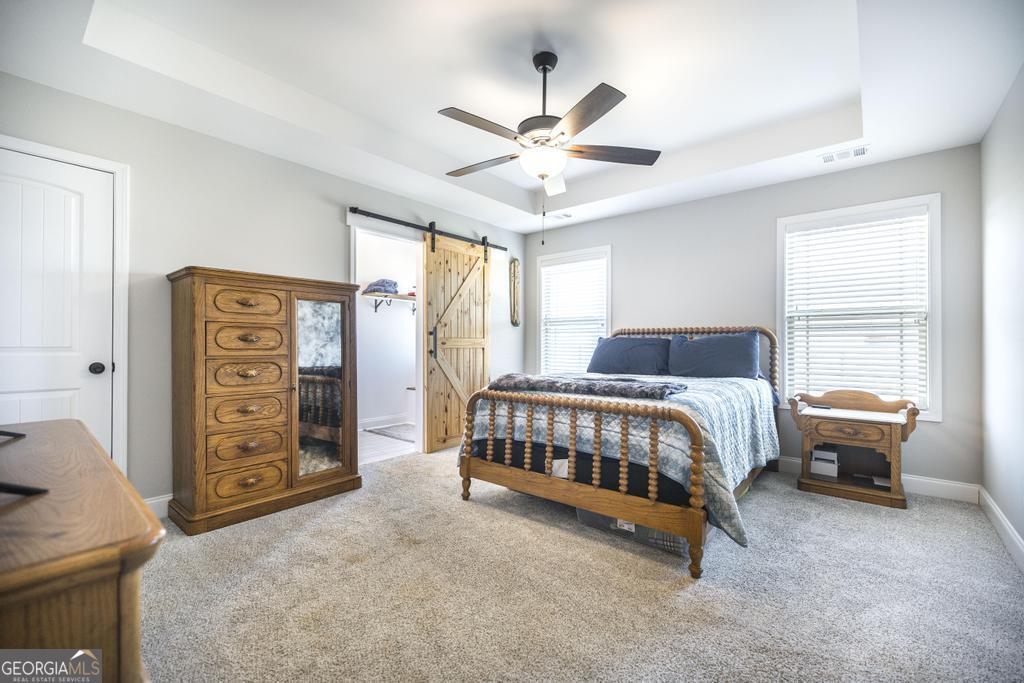 132 Sadie Heights Boulevard Perry, GA 31069 - Photo 15 of 29 a bedroom with a bed and a chandelier